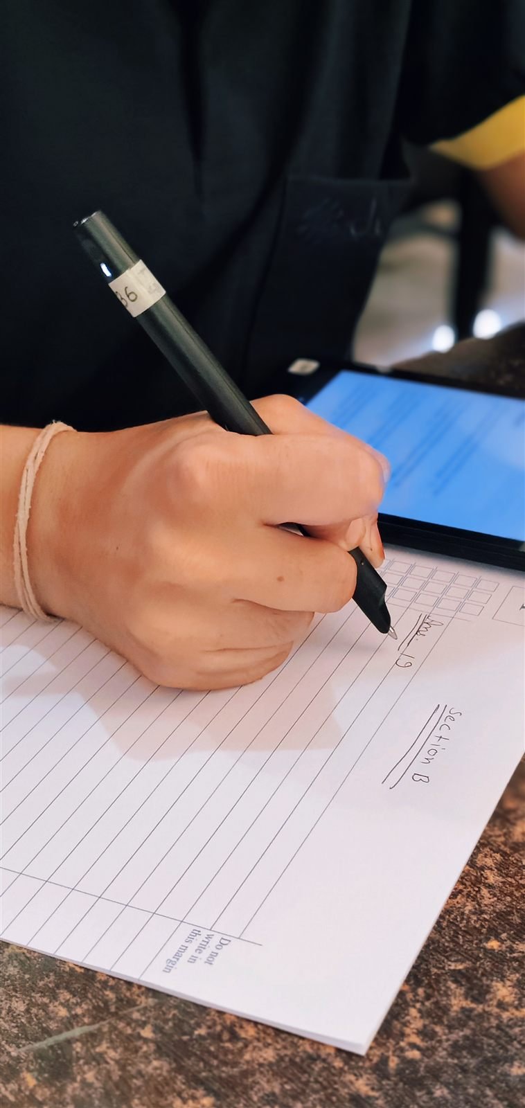 One desk: device, booklet, pen.